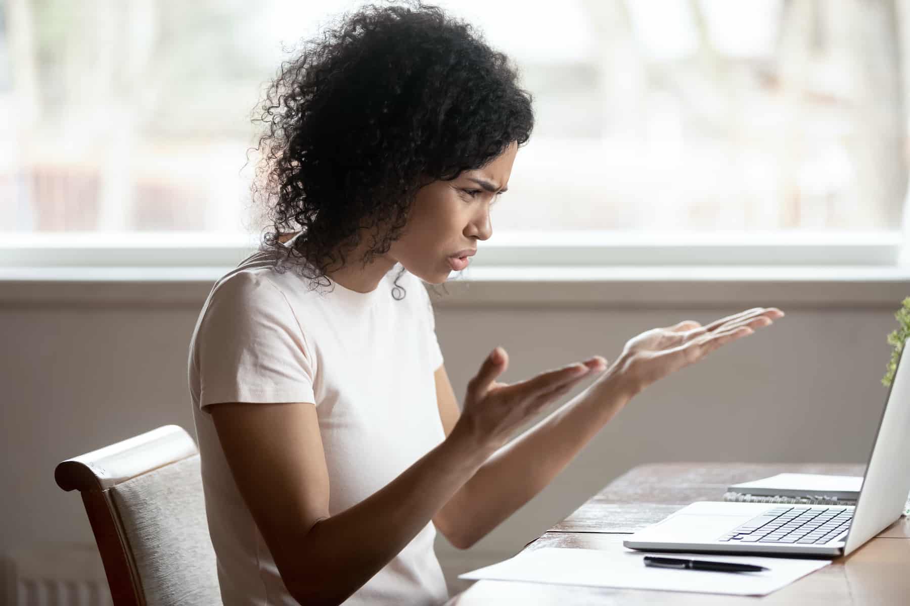 Mulher no topo de uma volta, palmas das mãos abertas para o teto, sulcos de sobrancelhas, expressando frustração