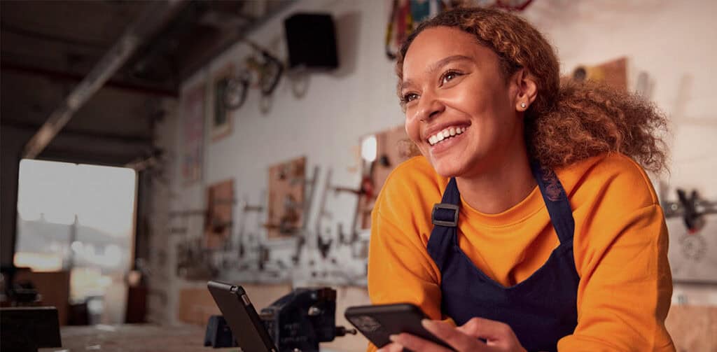 Imagem de uma mulher lendo os cases de sucesso da Signifyd no celular.