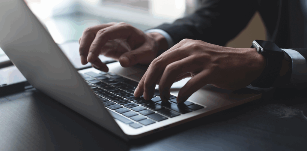 Pessoa digitando em um notebook e utilizando agentic commerce