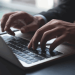 Pessoa digitando em um notebook e utilizando agentic commerce