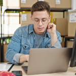 Homem usando notebook enquanto se preocupa com fraudes no e-commerce.