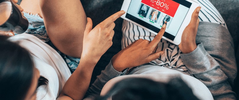 duas mulheres comprando online em um tablet em um site oferecem um grande desconto